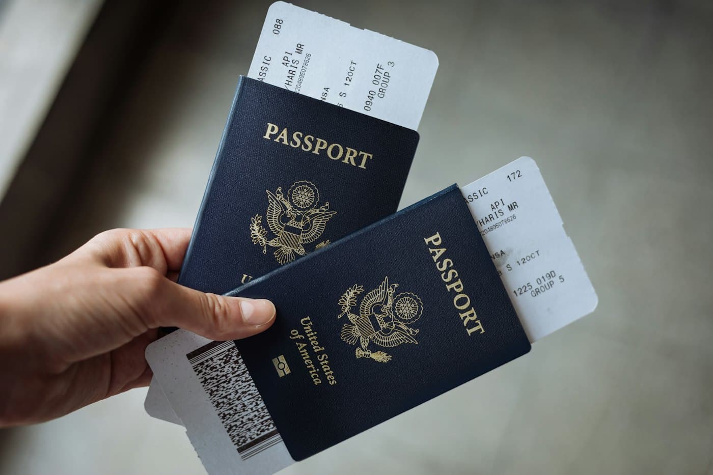 Une main tient deux passeports et des cartes d'embarquement